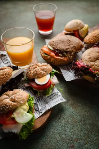 Belegde broodjes met glazen sinaasappelsap en andere dranken.