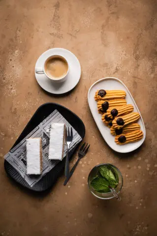 Koffie met verschillende kleine zoetigheden en gebakjes op tafel.